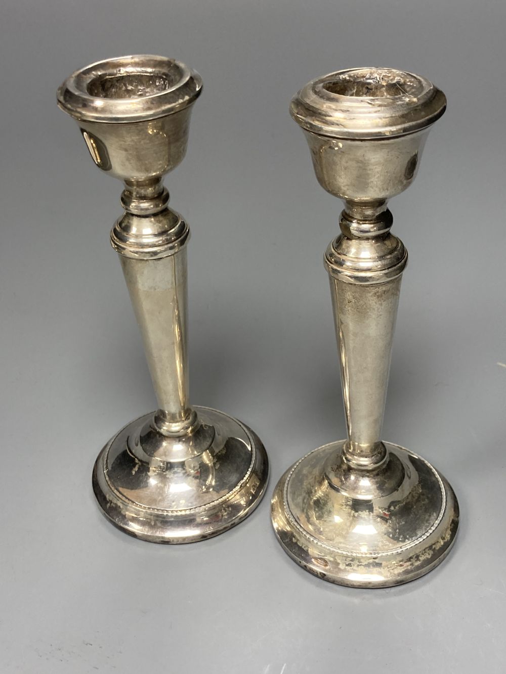 A pair of modern silver candlesticks, 15.6cm, weighted, a pair of George V silver shell salts and six coffee spoons